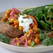 Baked sweet potato jackets topped with 15-Minute curry chickpea skillet stew with pink pickled onions and sour cream or dairy-free yogurt and roasted smoky pepitas. With a side of spinach salad. Easy, healthy, filling, plant-based, vegan recipe