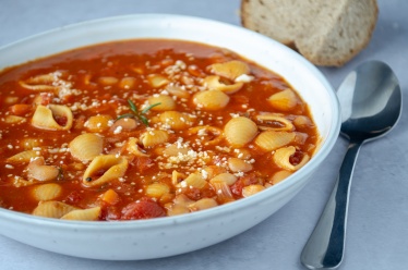 A bowl of pasta fagioli with pasta shells in a tomato sauce