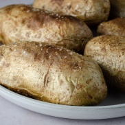 A plate of baked potatoes made quickly in the microwave with seasoning