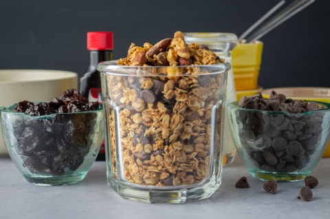 A jar of homemade Black Forest Granola with oats, almonds, chocolate chips, and dried cherries