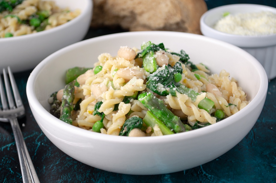 Bowl of pasta with asparagus, spinach, white beans, and parmesan cheese. Easy, healthy, filling, plant-based, vegan recipe