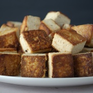A plate of crispy brown seared tofu cubes