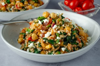 A plate of Greek Flavored rice with chickpeas, tomatoes, spinach and feta