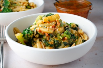 A bowl of sundried tomato pesto pasta with broccoli