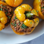 Vegan stuffed peppers made with lentils, walnuts, rice, and tomato sauce