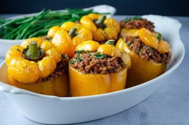 Vegan stuffed peppers made with lentils, walnuts, rice, and tomato sauce