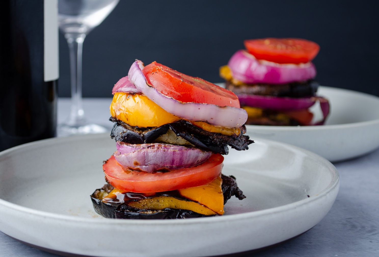 Grilled Portobello Mushroom with red wine mushroom sauce and served in a stake with grilled peppers, tomatoes, and onions
