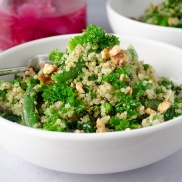 A warm green and grain salad made from quinoa and massaged kale and tossed with pesto