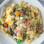 Rotini pasta with parmesean cheese and roasted summer vegetables of squash, zucchini, and eggplant topped with basil