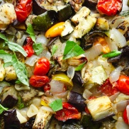 A tray of roasted summer vegetable ratatouille with zucchini, squash, eggplant, garlic, and fresh herbs