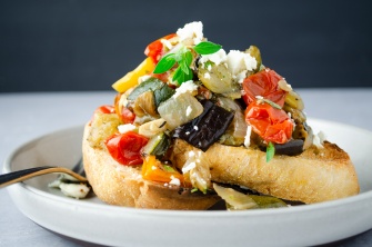 Ratatouille of roasted summer vegetables made from squash, zucchini, and eggplant, on toast