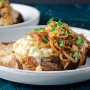 White beans and caramelized onions on rustic french bread toast