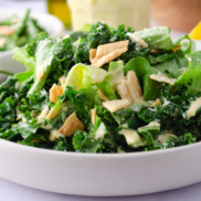 A bowl of vegan caesar salad made with kale and butter lettuce for texture and a planet-friendly dairy-free caesar dressing