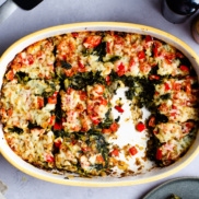 A casserole dish of hash brown strata with kale, peppers, potato hash browns that is filling, delicious, and vegan