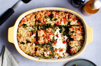 A casserole dish of hash brown strata with kale, peppers, potato hash browns that is filling, delicious, and vegan