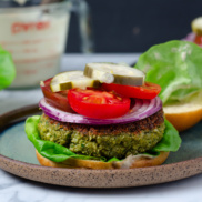 A plant-based, protein-full falafel burger on a bun with lettuce, onion, tomato, and pickles