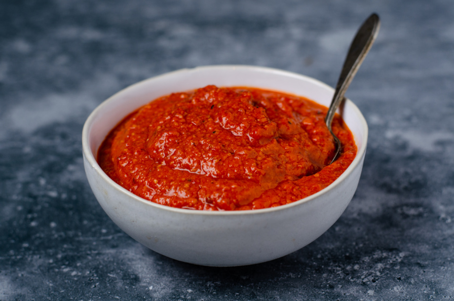 A bowl of lightly sweet and zippy romesco sauce with roasted red peppers and sundried tomatoes perfect for serving with falafel for a plant-based entree