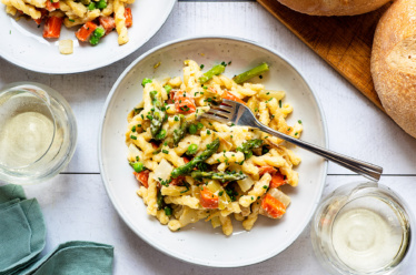 A bowl of warm, bright, zesty, pasta primavera made from roasted spring vegetables of asparagus, potato, leek, radish and/ or fennel and tossed with a zesty, dairy-free, vegan cauliflower alfredo