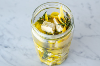 A jar of lemon-rosemary brined. dairy-free plant-based feta cheese made from tofu