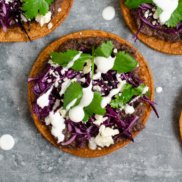 Black bean tostadas with cabbage, cotija cheese, sour cream, and cilantro