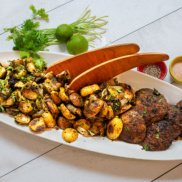 A sheet pan dinner of roasted Brussels sprouts and portabella mushrooms, topped with a chimichurri sauce