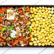 A sheet pan tray of skillet gnocchi with mushrooms, tomatoes, and feta