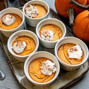 Ramekins of festive baked pumpkin custard made from dairy-free, egg-free, plant-based pumpkin pie filling.