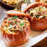 Festive roast pumpkins stuffed with plant-based filling of rice, mushrooms, and herbs for a show-stopping turkey alternative