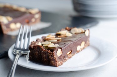 A white dish with a vegan, dairy-free, gluten-free, plant-based chocolate almond tart