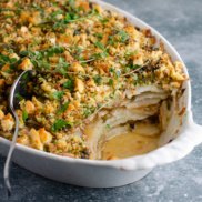 A casserole dish of plant-based, dairy-free, potato gratin with caramelized onions and crumble topping